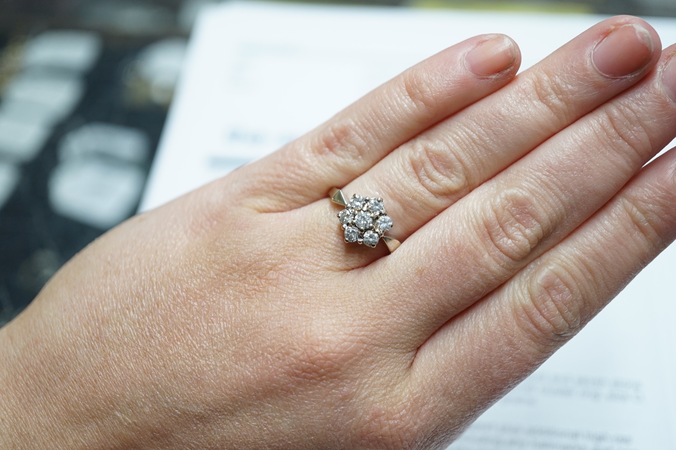 A modern 18ct white gold and seven stone diamond set hexagonal cluster ring, size O, gross weight 3.9 grams.